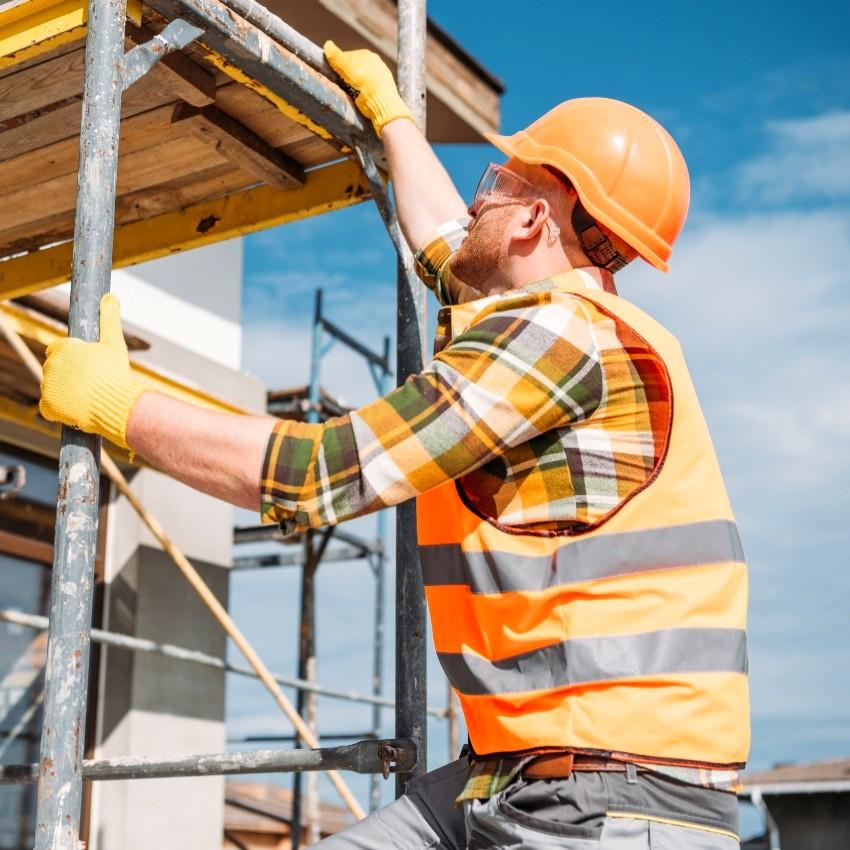 Un homme en tenue de chantier et un casque orange