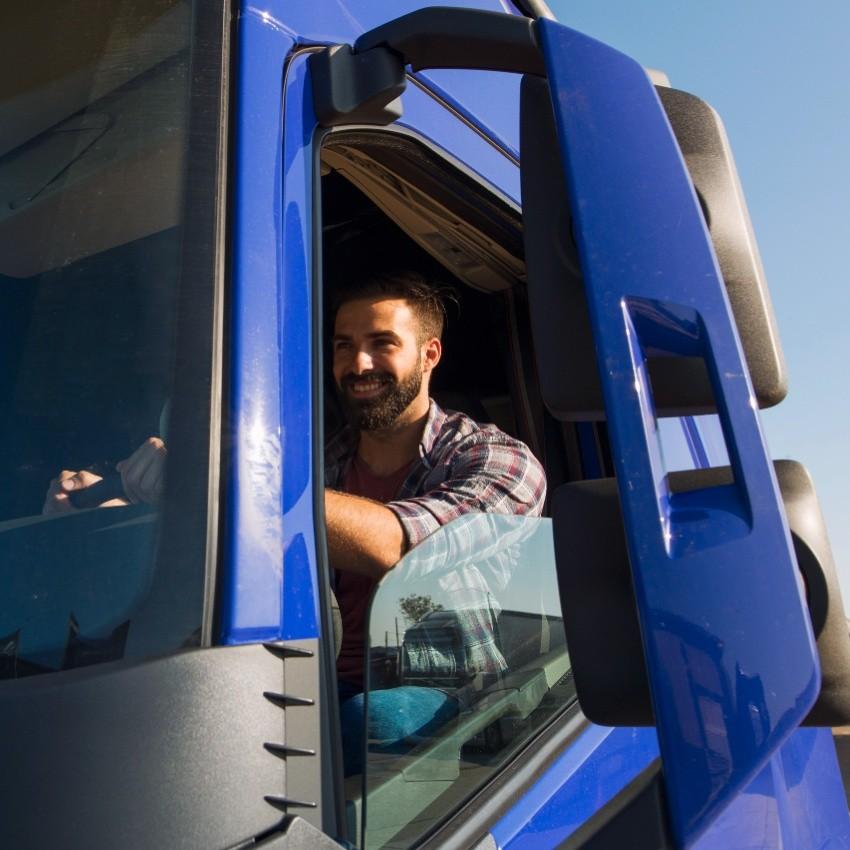 Un homme conduisant un camion poids lourd bleu